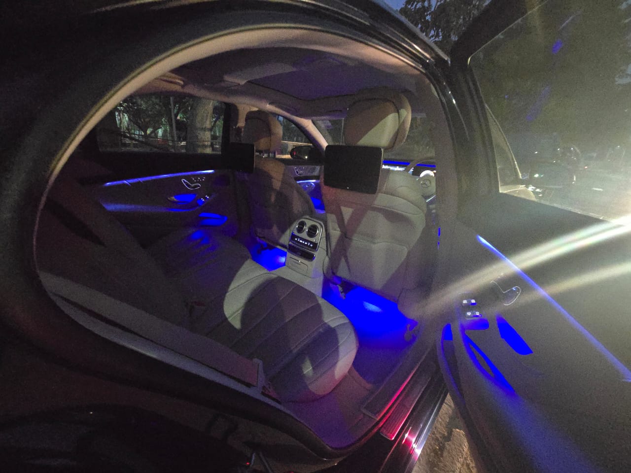 Rear cabin with blue ambient lighting and entertainment screens